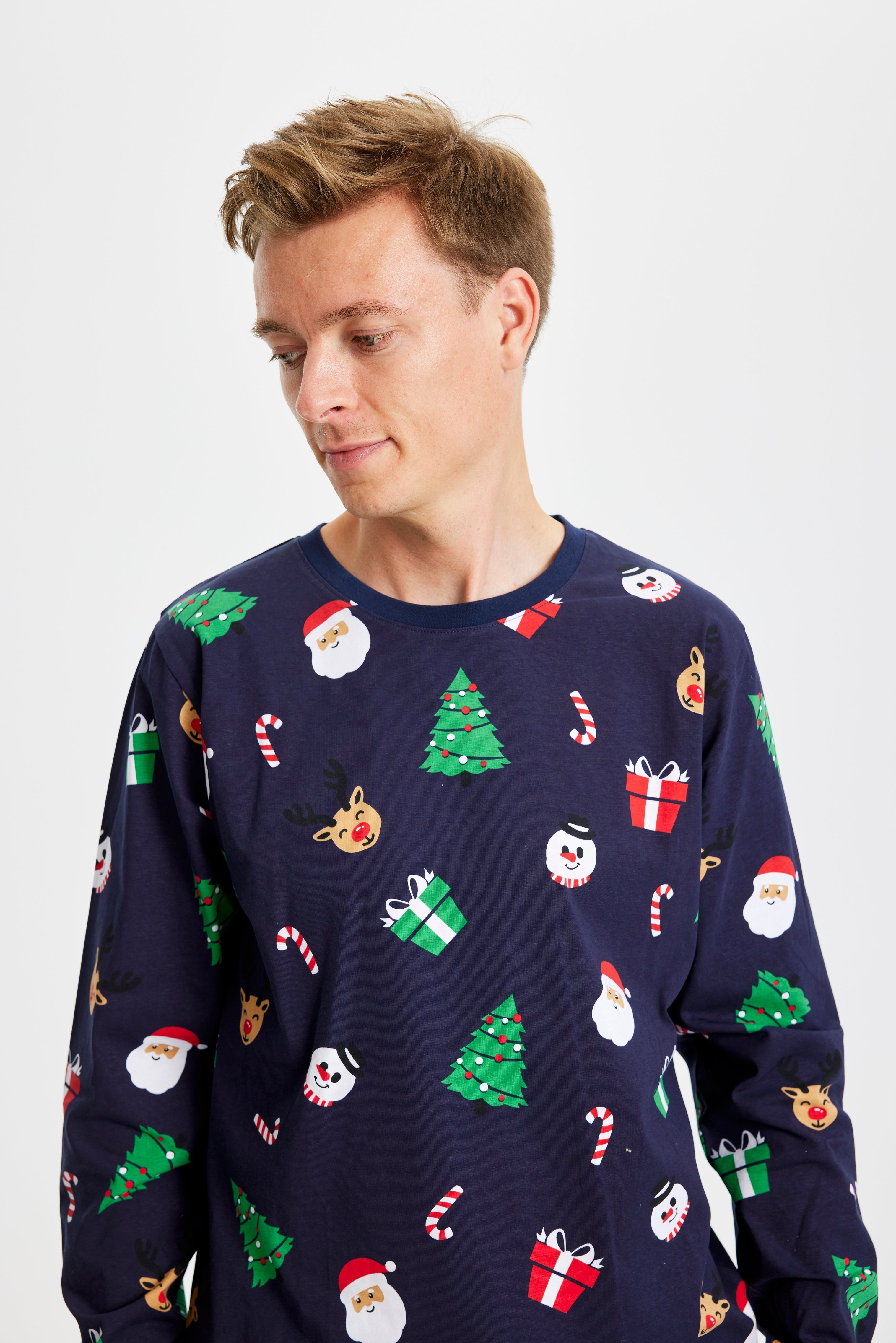 Eine Frau in einem blauen Weihnachtspyjama mit Weihnachtsbäumen.
